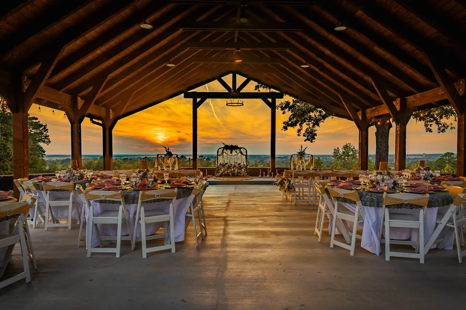 Golden sunset beyond reception tables and timber beams in The Tower pavilion